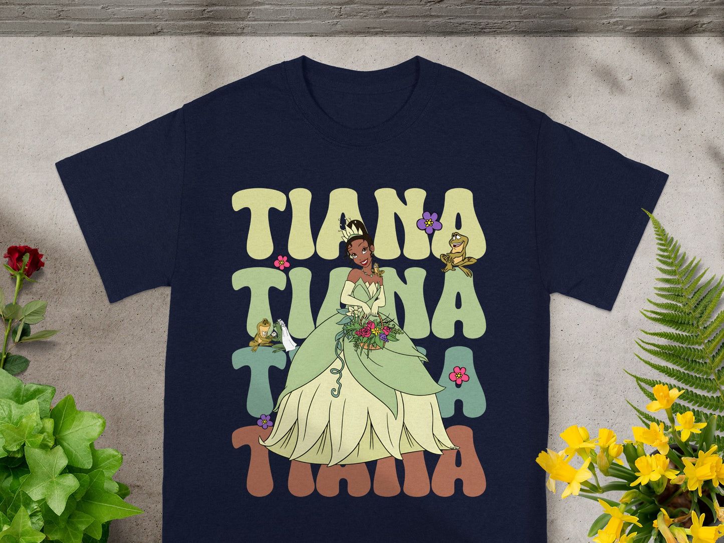 Navy t-shirt with "Tiana" in colorful retro lettering and character illustration.