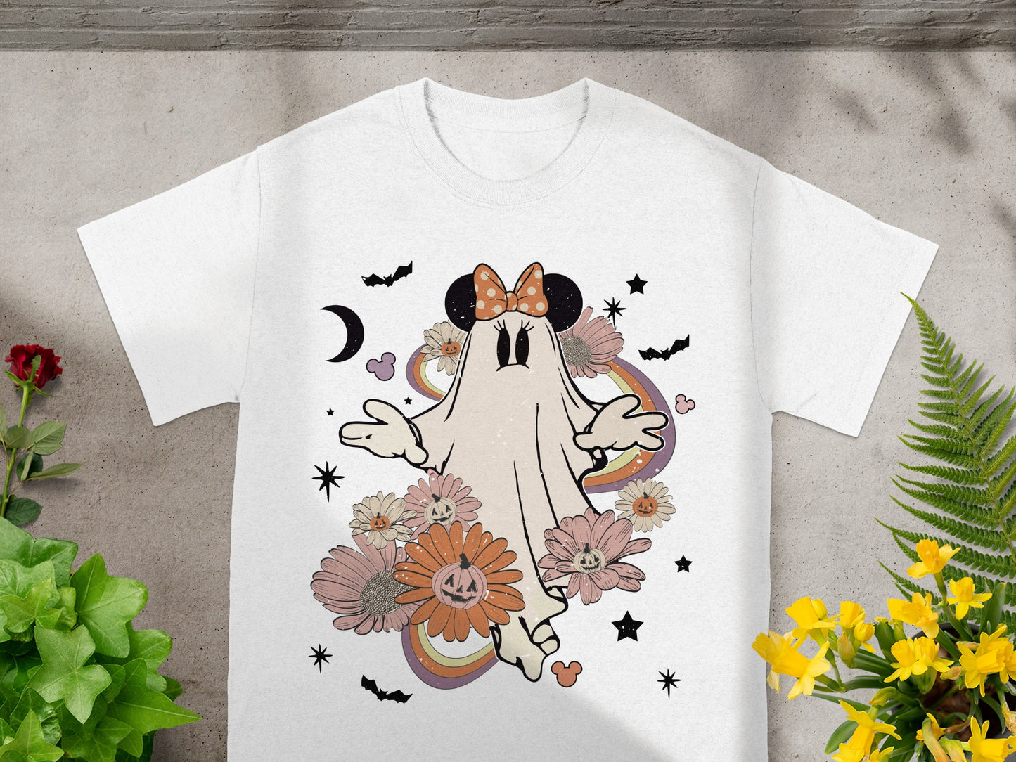 White t-shirt with a vintage ghost design, pumpkins, flowers, bats, and moon.
