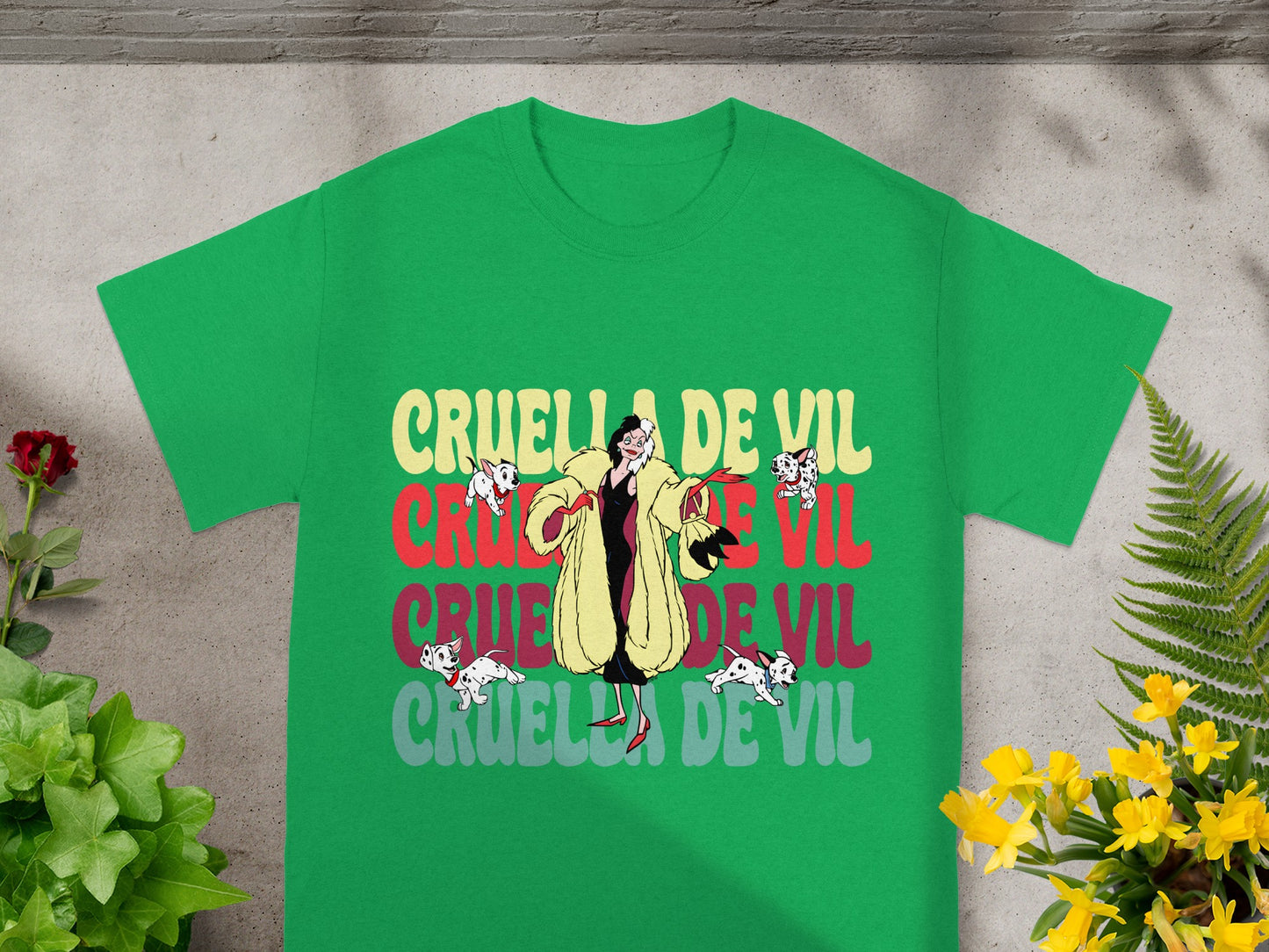Green t-shirt with "Cruella De Vil" in distressed lettering and cartoon dogs.