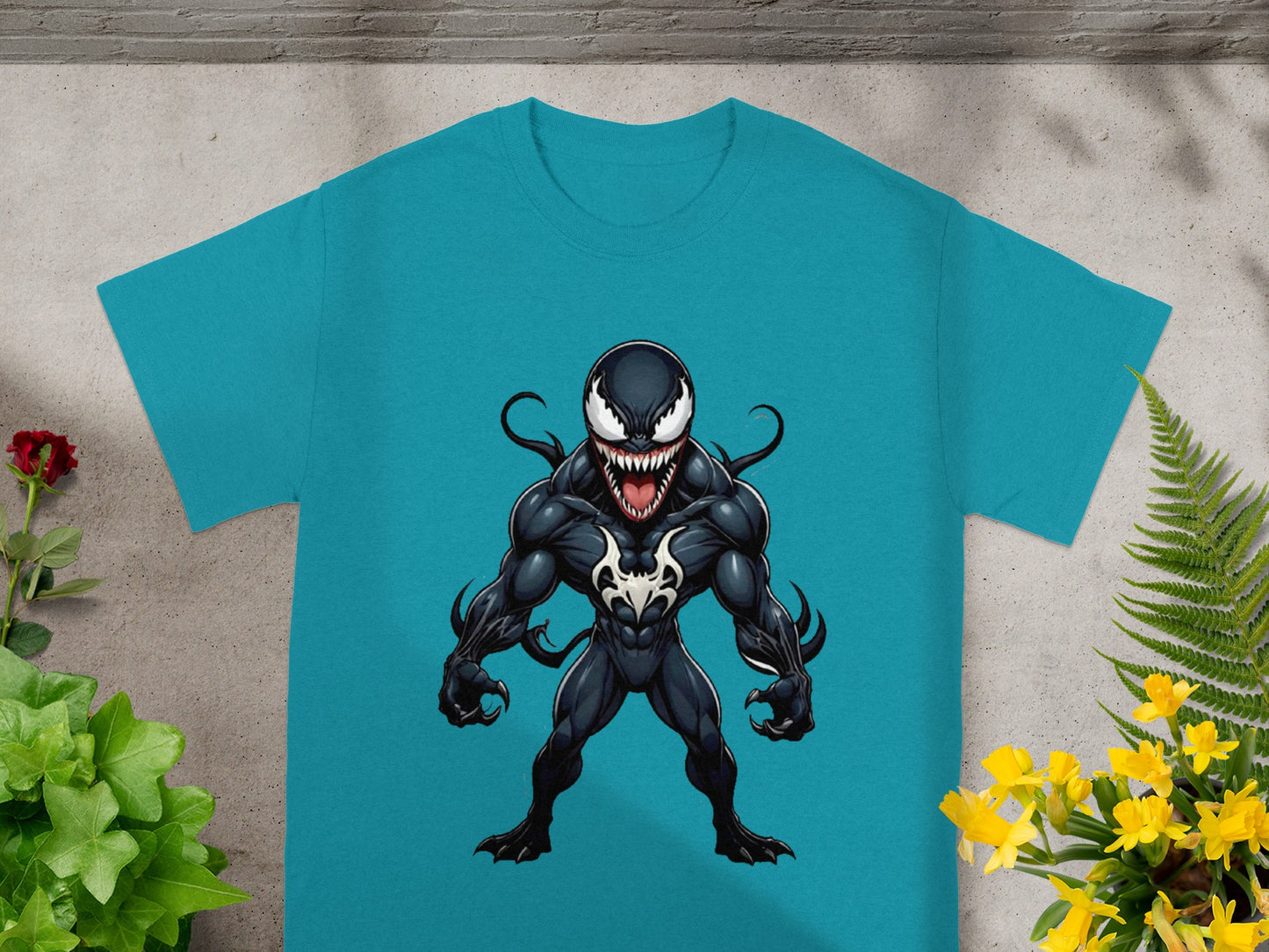 Venom t-shirt with a black and white character illustration on a teal tee.