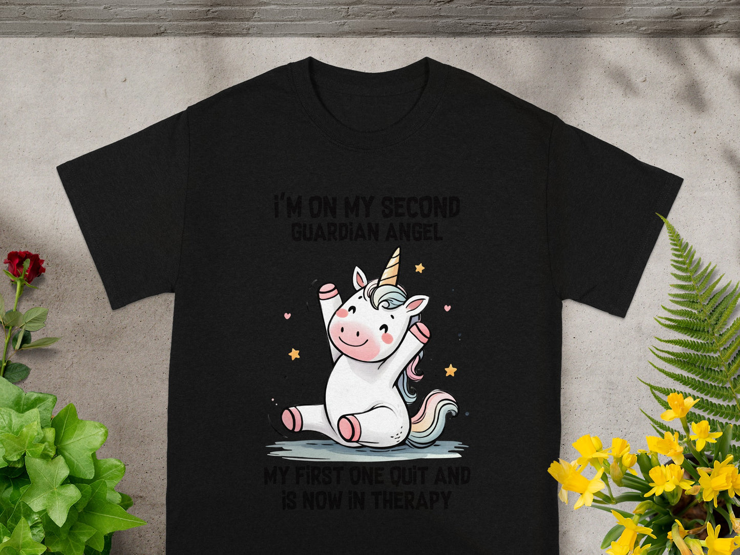 Black t-shirt with cartoon unicorn and text "I'm on my second guardian angel. My first one quit and is now in therapy."