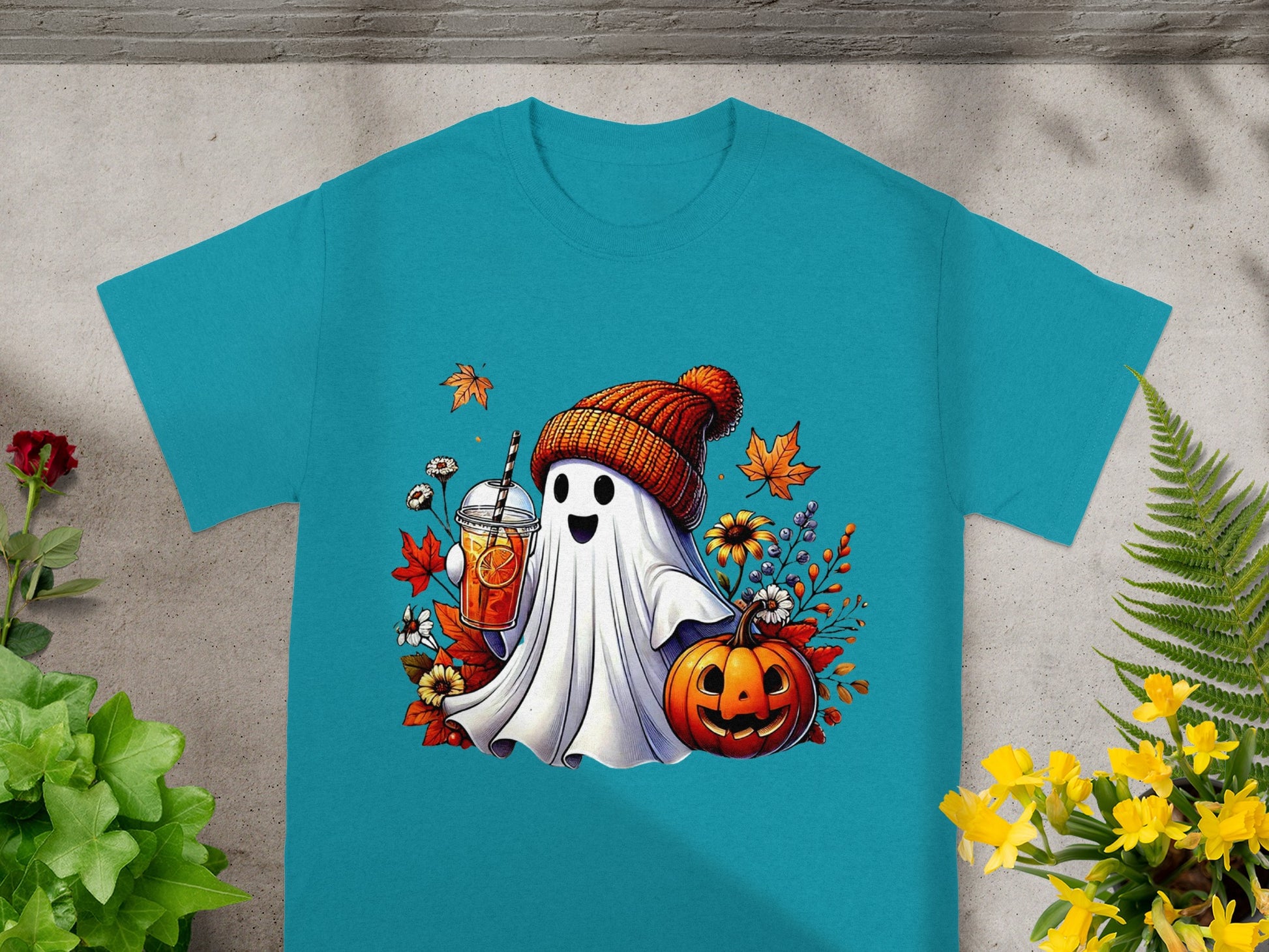 Ghost holding drink, wearing beanie, with pumpkin and autumn leaves.
