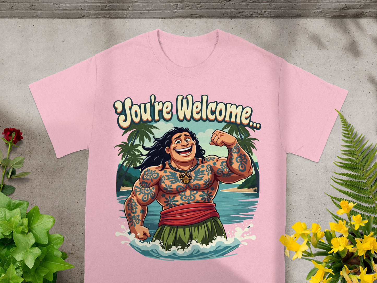 Pink t-shirt with cartoon of tattooed man smiling and flexing, "You're Welcome," text.
