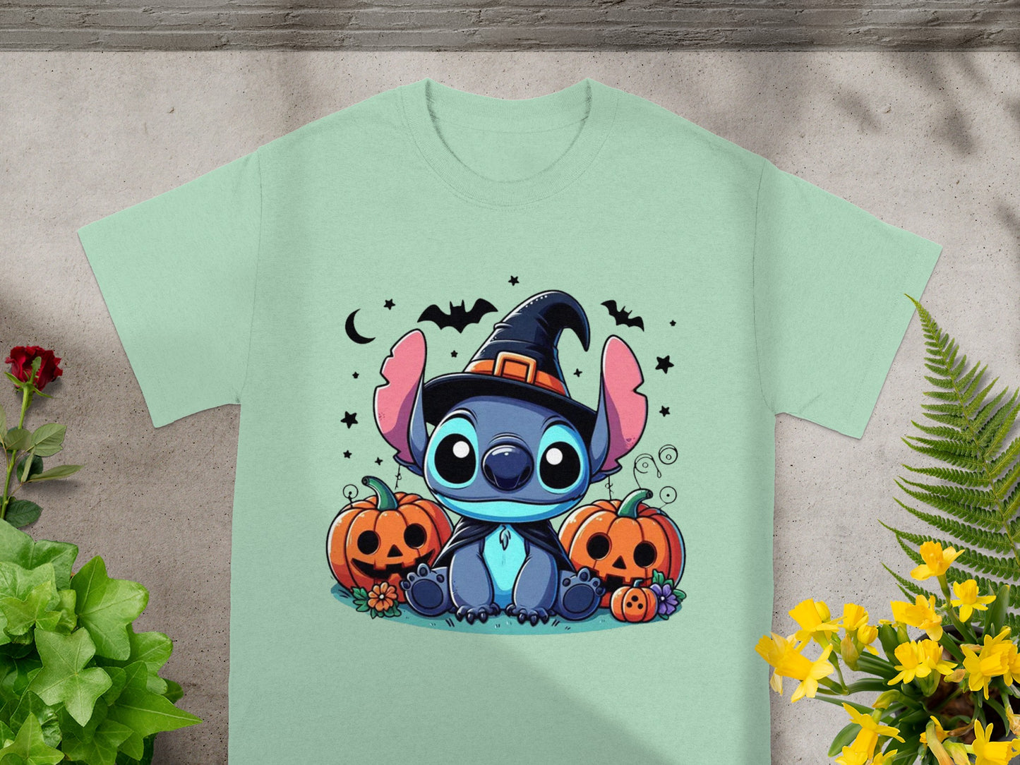 Stitch in a witch hat sits between pumpkins under a moon and bats.