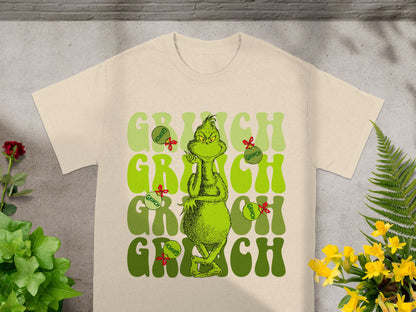 Cream t-shirt with Grinch graphic and "Grinch" text.