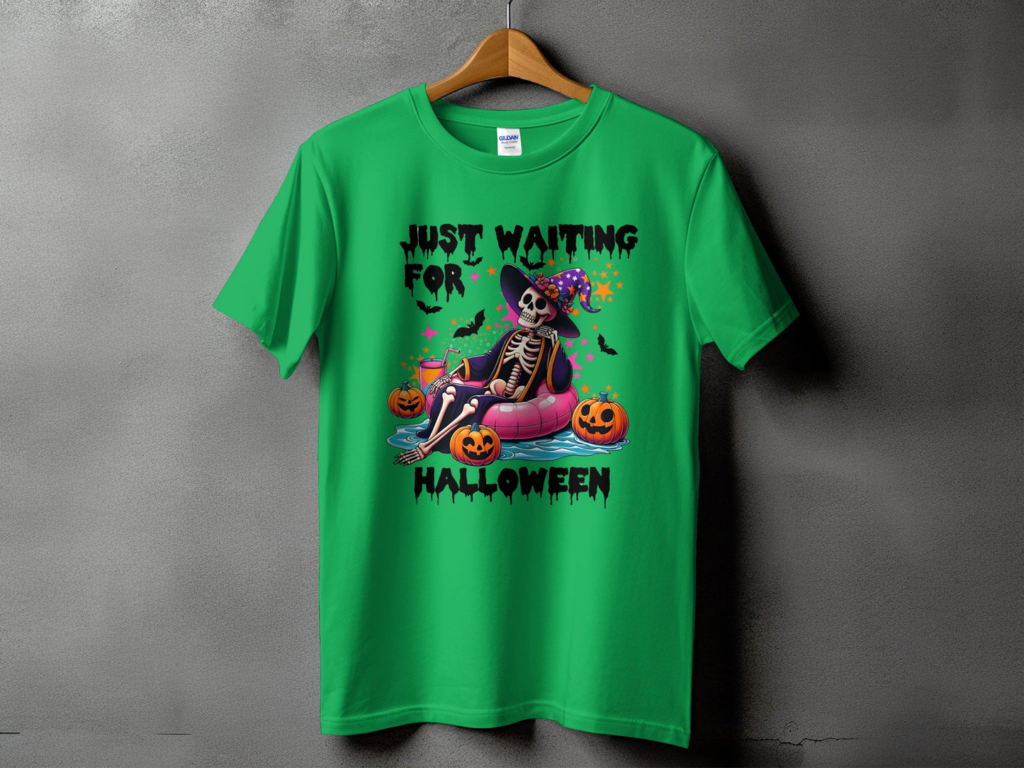 Green t-shirt with skeleton in witch hat, pumpkins, and text "Just Waiting For Halloween".