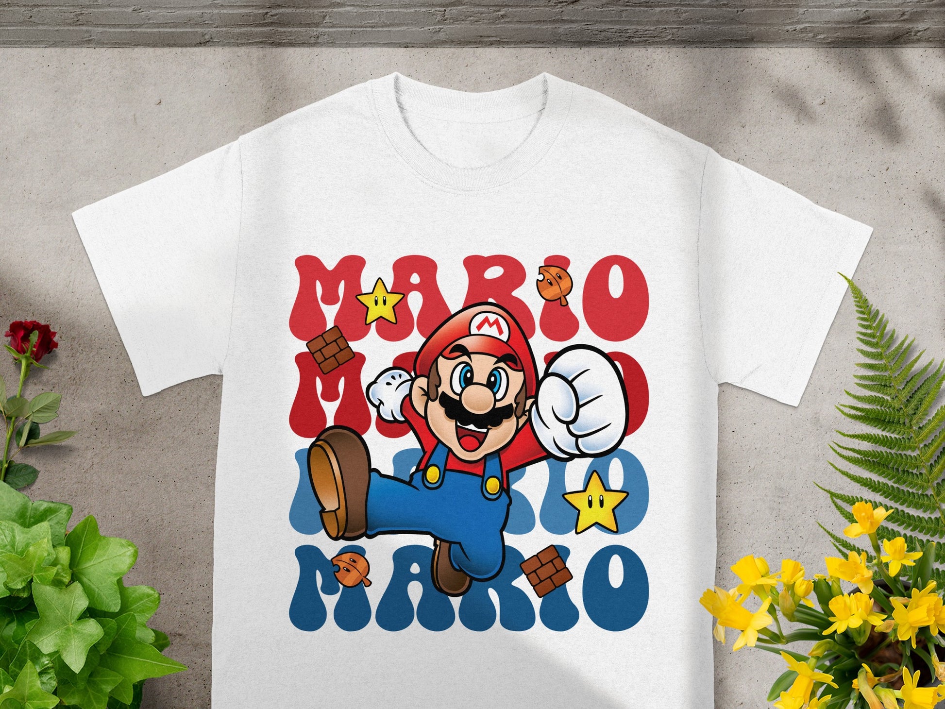 Mario in his signature pose on a white t-shirt with red and blue text.