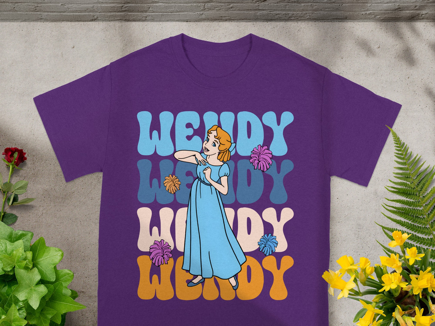 Purple t-shirt with "Wendy" in colorful wavy letters and a cartoon girl.