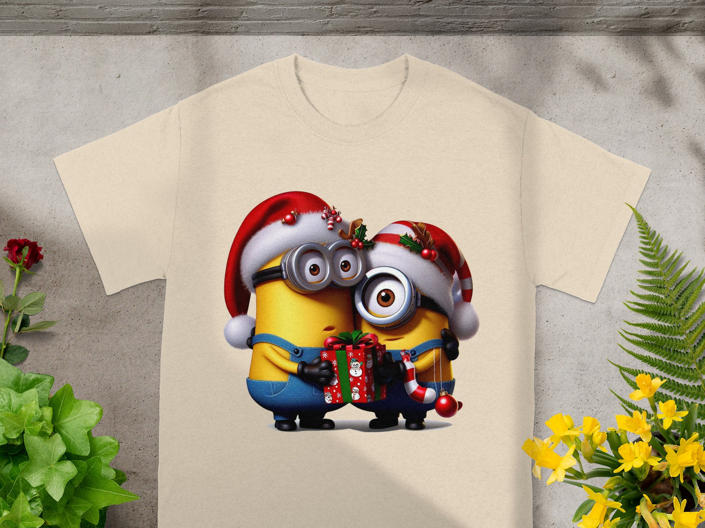 Two Minion characters in Santa hats hug, holding a Christmas gift and candy cane.