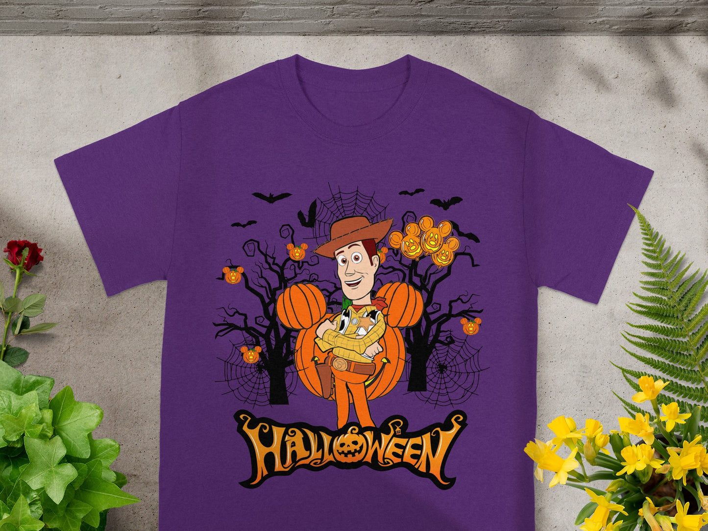 Woody character with pumpkins and Halloween text on a purple t-shirt.