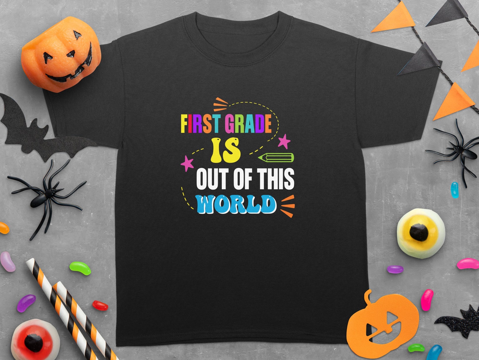 T-shirt featuring colorful text that reads "FIRST GRADE IS OUT OF THIS WORLD".