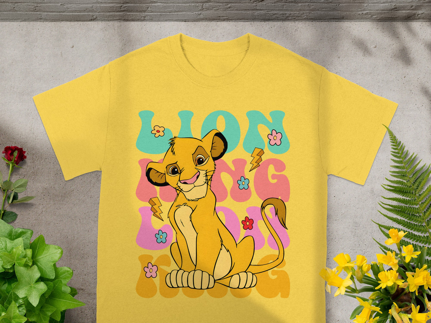 Yellow t-shirt with Simba from The Lion King and colorful "LION KING" text.