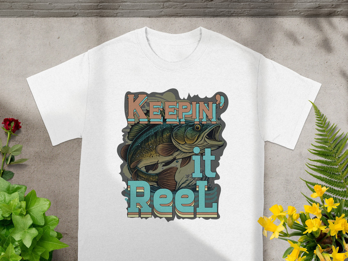 White t-shirt with graphic "Keepin' it Reel" and a leaping bass.
