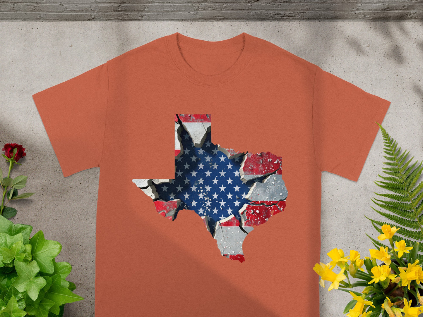 Orange t-shirt with a cracked Texas shape filled with the American flag design.