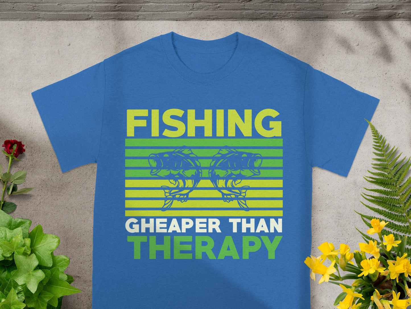 Blue shirt with yellow and green text "FISHING CHEAPER THAN THERAPY" and fish graphic.
