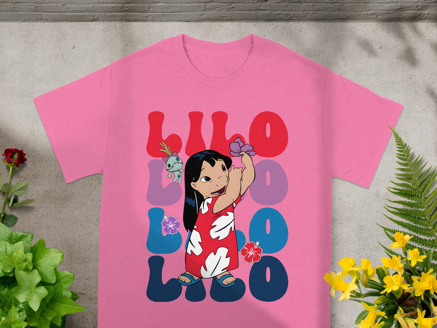 Pink t-shirt with Lilo & Stitch graphic and colorful text.