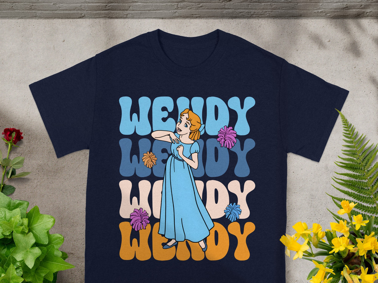 Navy t-shirt with "Wendy" repeated in colorful retro lettering and cartoon Wendy character.