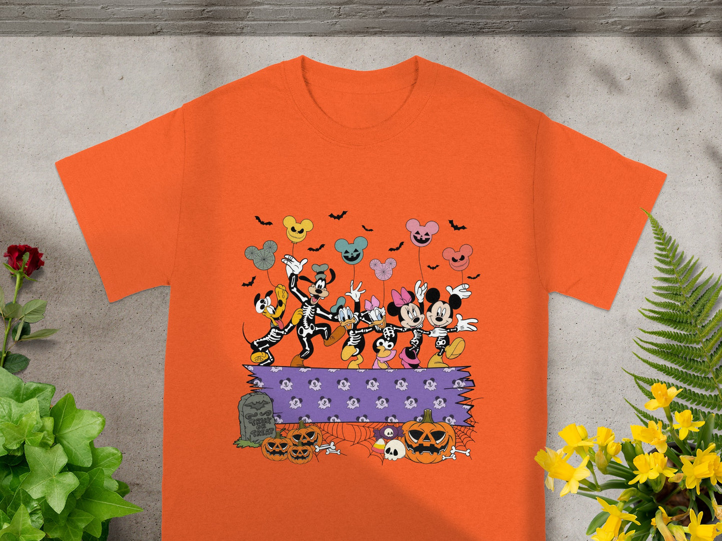 Orange t-shirt with Disney characters dressed as skeletons and Halloween-themed graphics.