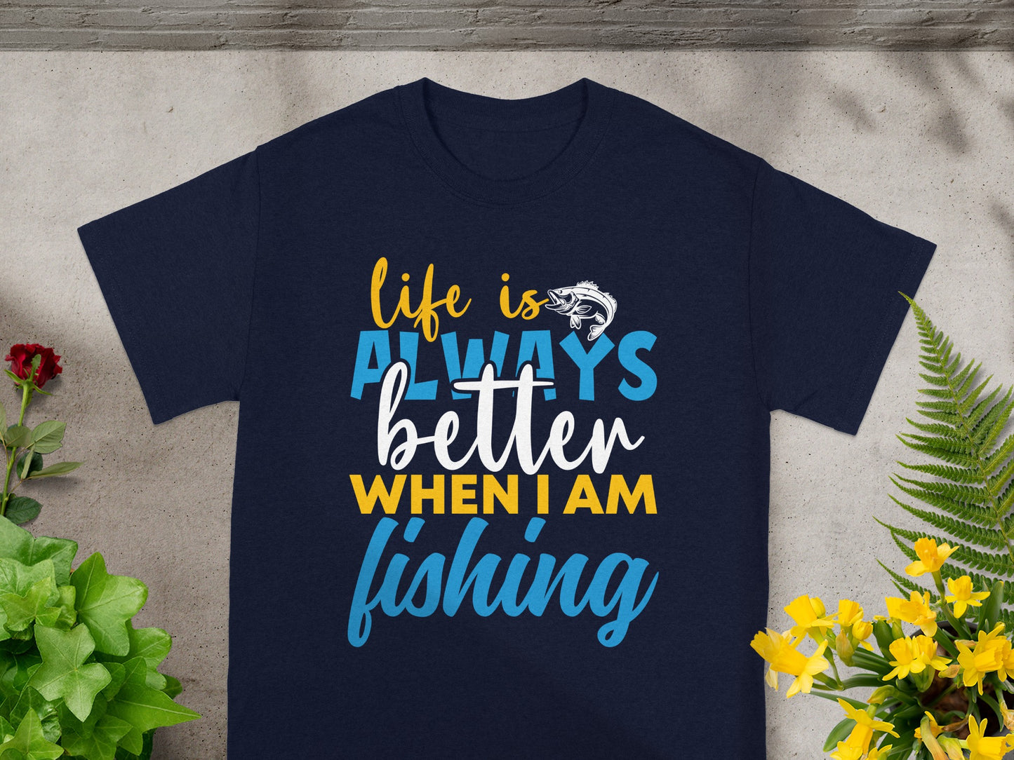 Dark navy t-shirt with white, blue, and yellow text "life is better when I am fishing".