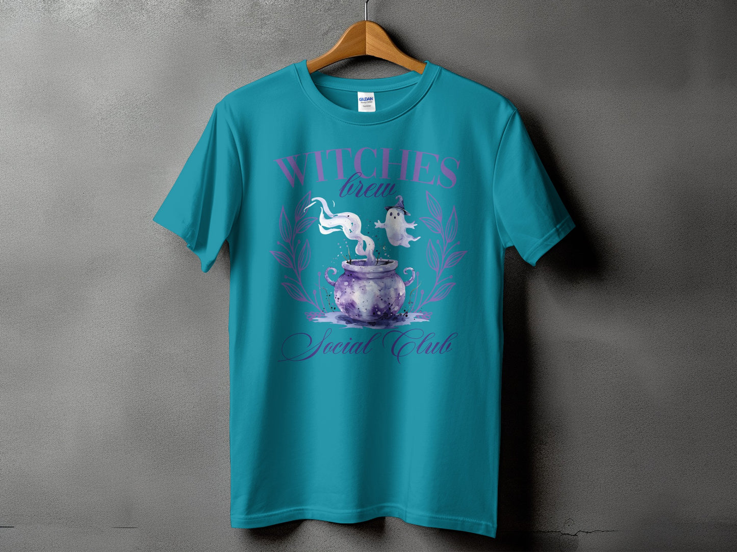 Teal t-shirt with "Witches Brew Social Club" text and spooky cauldron graphic.