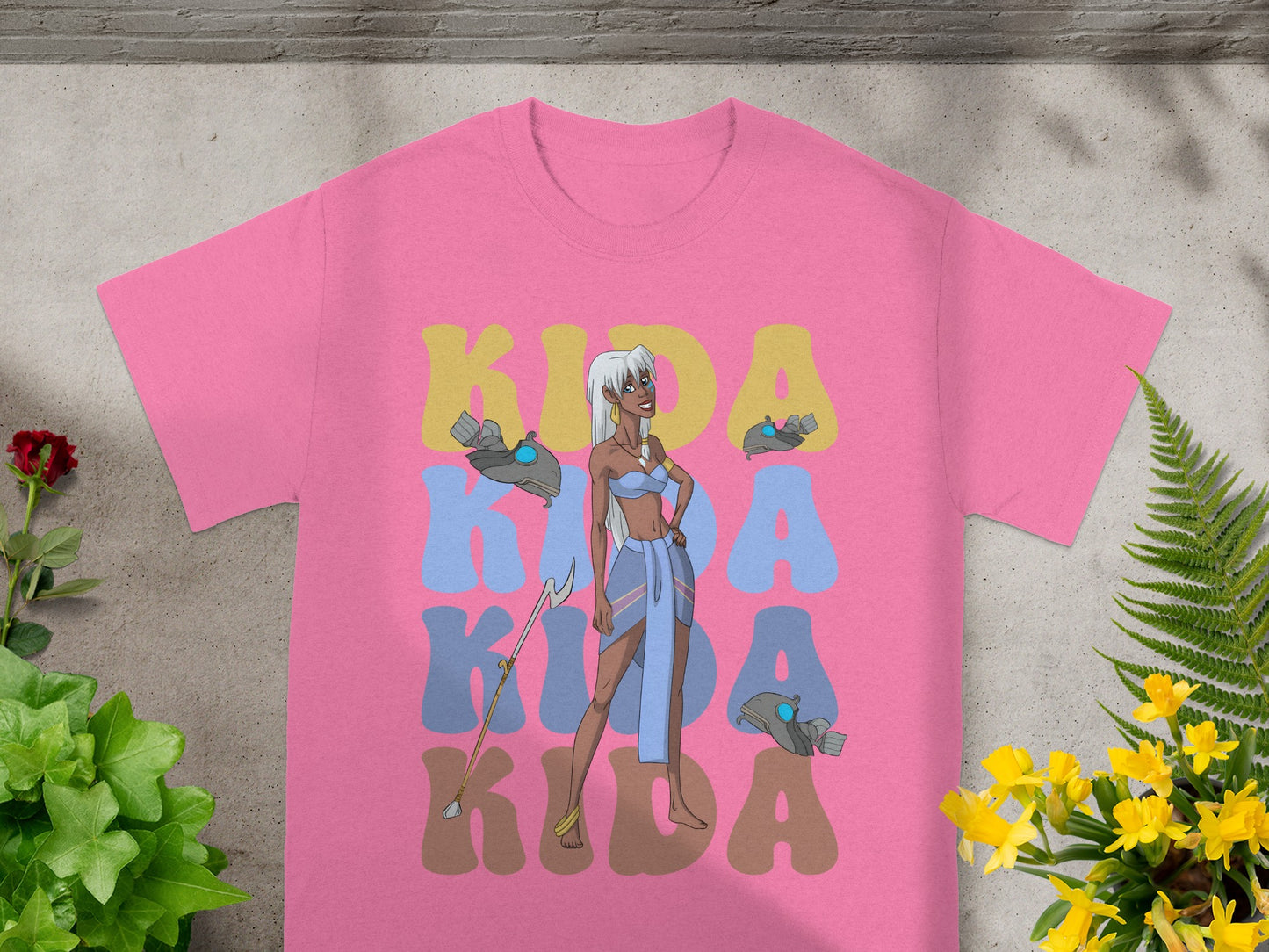 Pink t-shirt with "Kida" in large colorful letters and a character illustration.