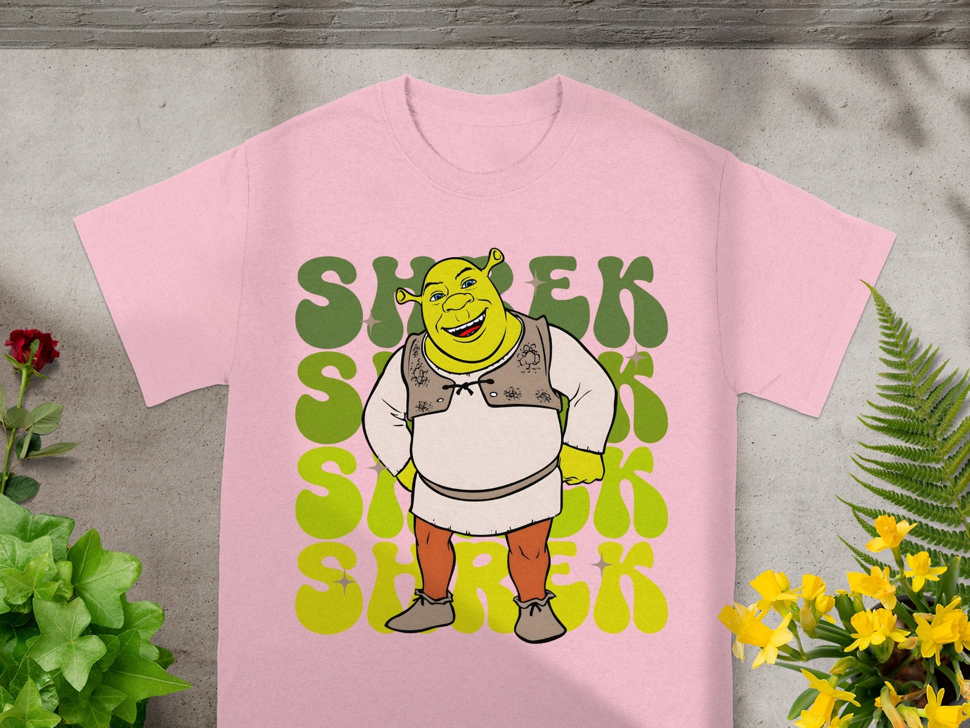 Pink t-shirt with large green "Shrek" text and cartoon Shrek character.
