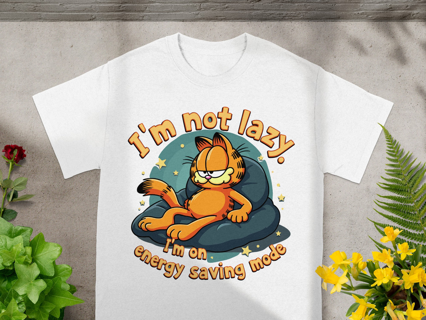 White t-shirt with Garfield lying on a pillow, text "I'm not lazy. I'm on energy saving mode."