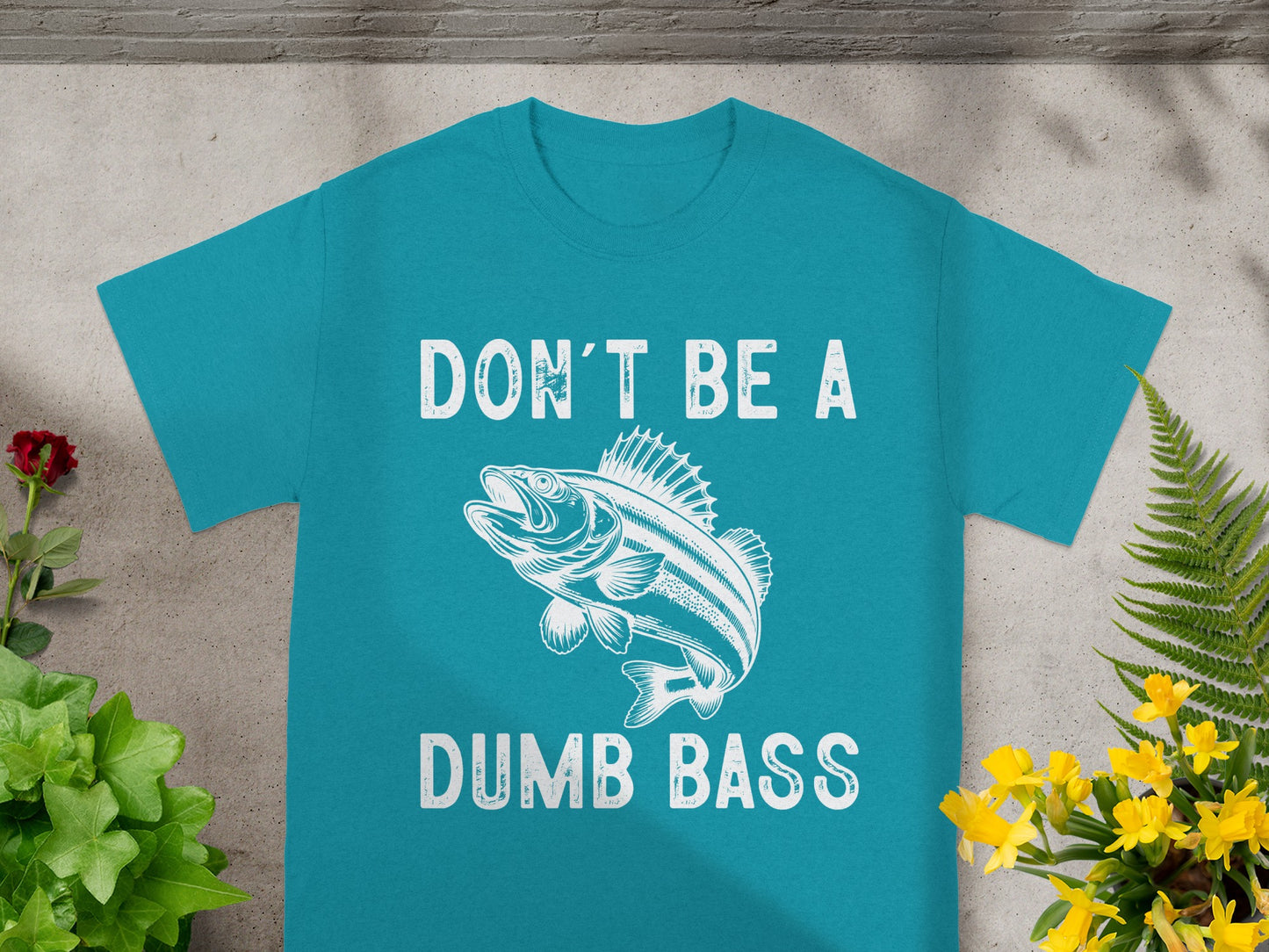 Teal t-shirt with white text "DON'T BE A" and drawing of a bass fish.