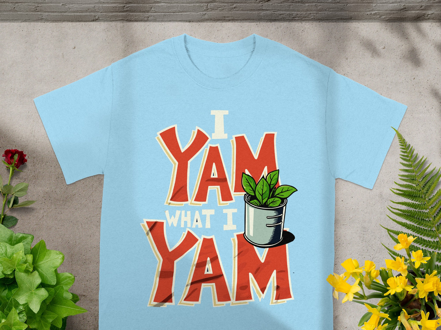 Light blue t-shirt with red text "I Yam What I Yam" and a small potted plant.
