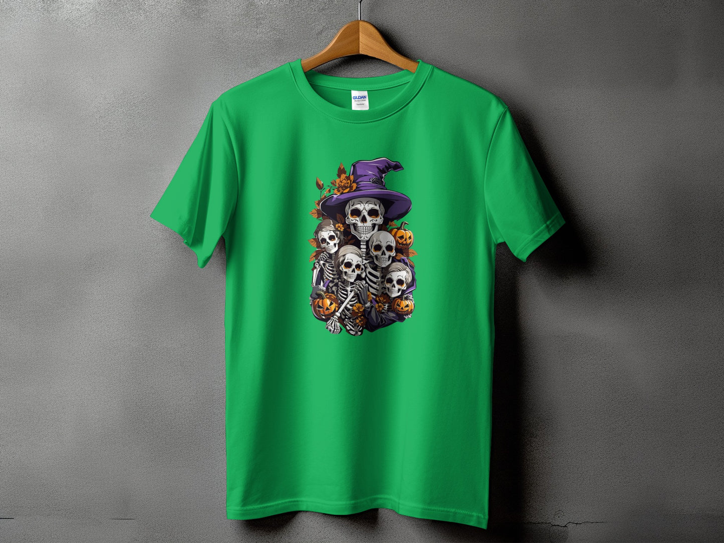 Green t-shirt featuring a Halloween graphic of skeletons, pumpkins, and a witch hat.
