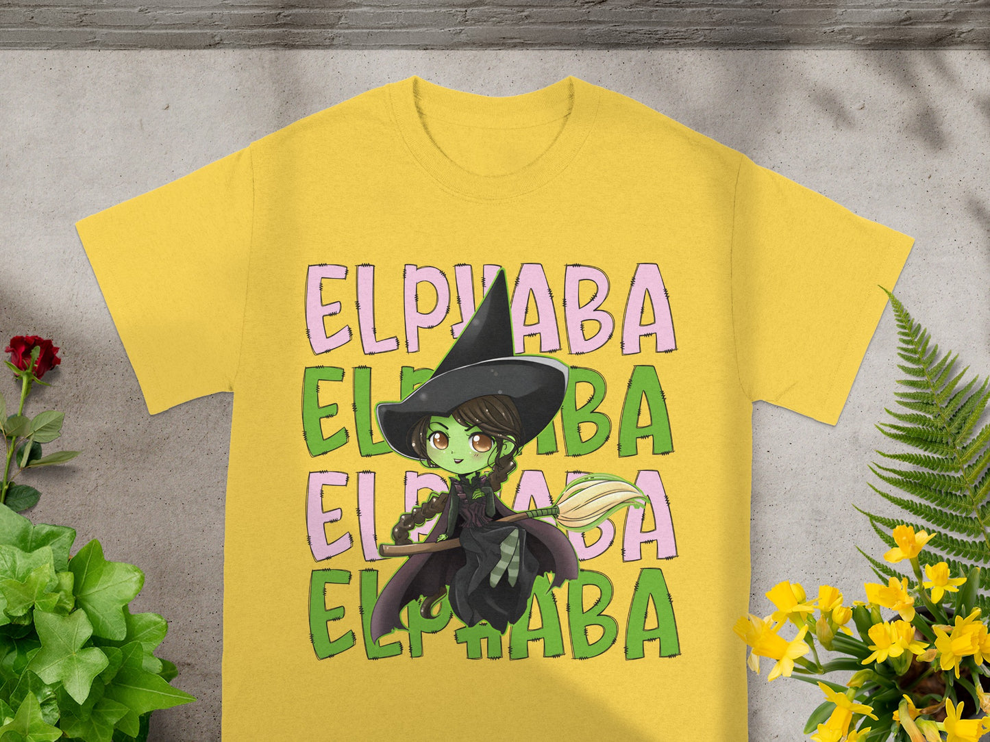 Yellow t-shirt with green Elphaba witch graphic and text.