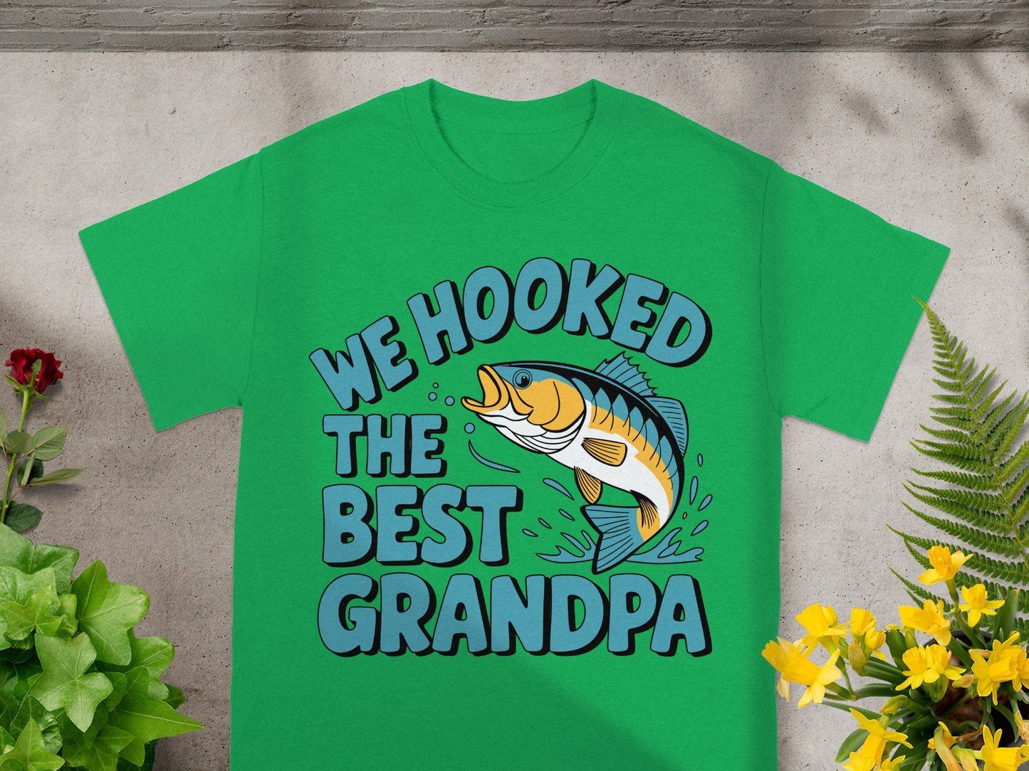Green t-shirt with "We hooked the best Grandpa" text and a jumping fish design.