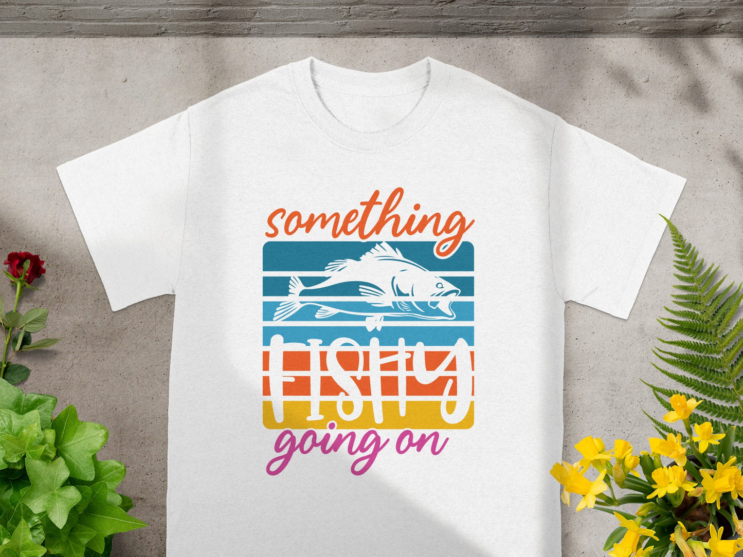White t-shirt with fish graphic and text "something fishy going on."