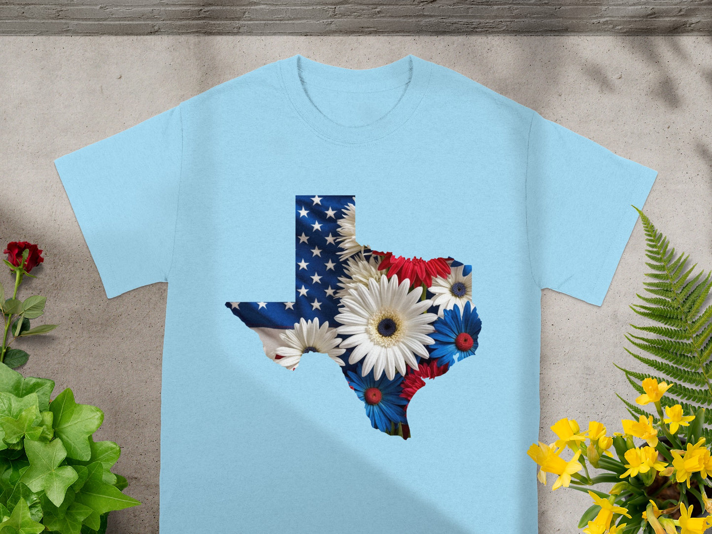 Light blue t-shirt with Texas outline filled with American flag and flowers.