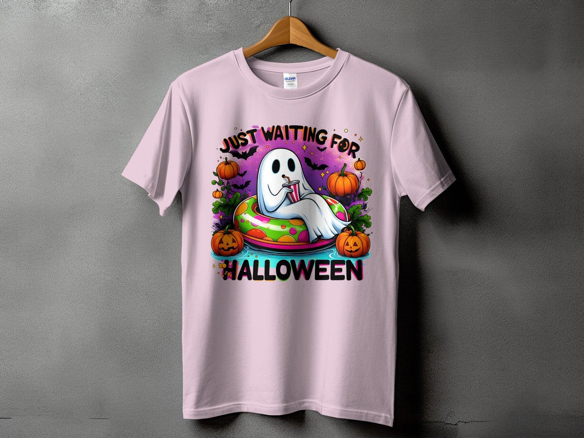 Pink t-shirt with a cartoon ghost in a pool ring saying "Just Waiting For Halloween."