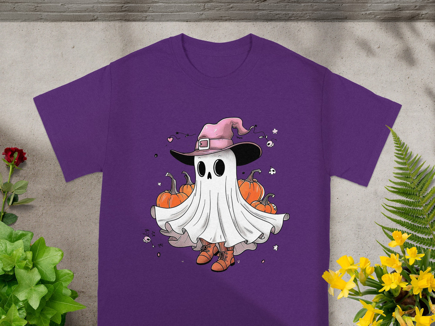 Purple t-shirt featuring a cartoon ghost in a witch hat with pumpkins.