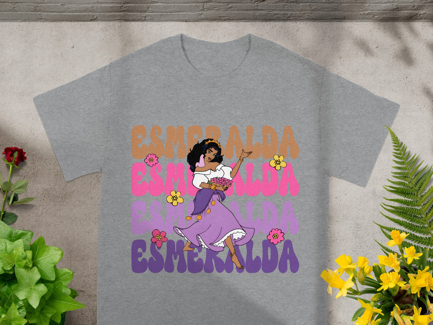 Esmeralda in purple dress on grey t-shirt with colorful text.