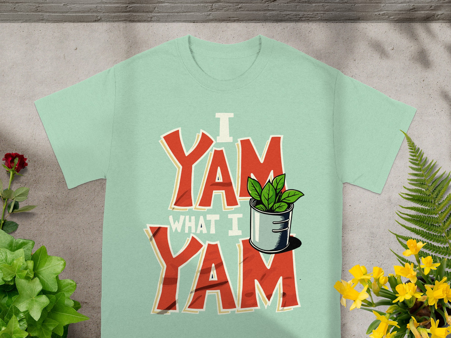 Mint t-shirt with red "I Yam What I Yam" text and green potted plant.