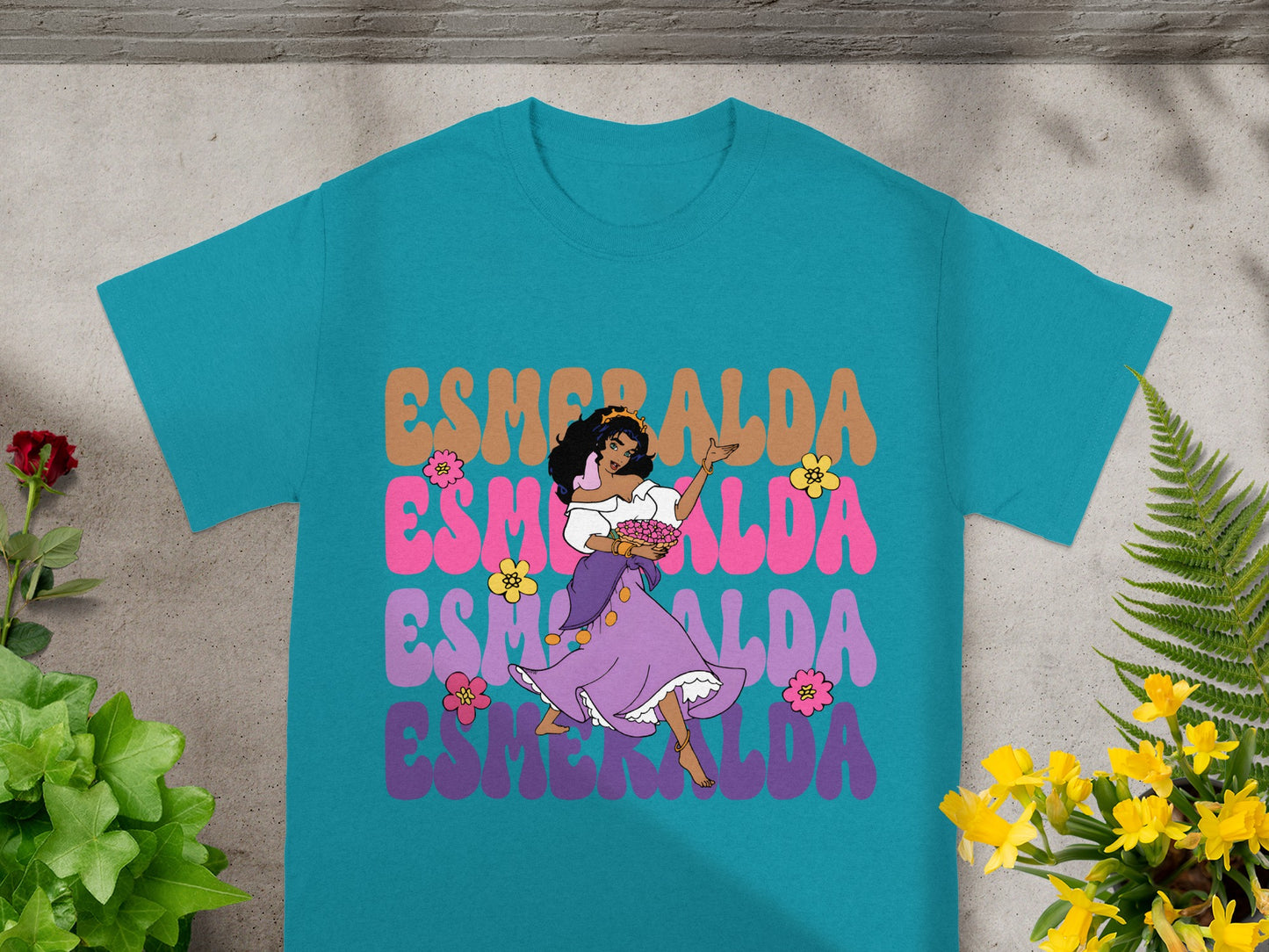 Teal t-shirt with Esmeralda dancing and holding flowers.