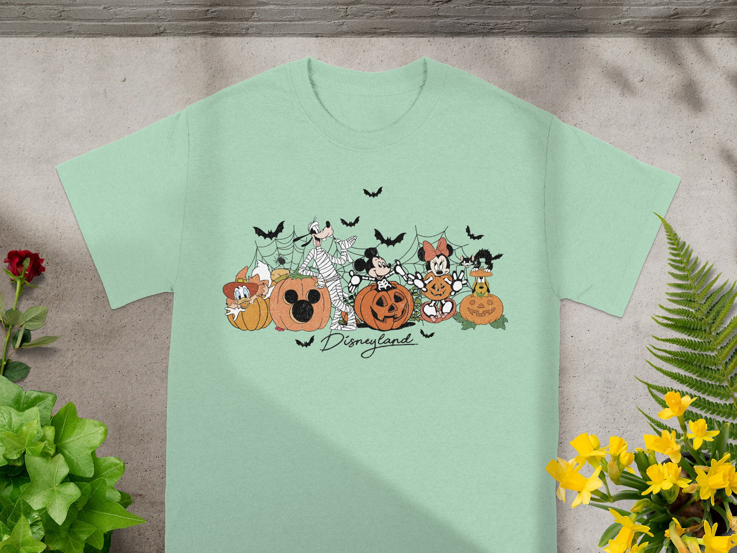 Disney characters in Halloween costumes with pumpkins and bats, Disneyland text.