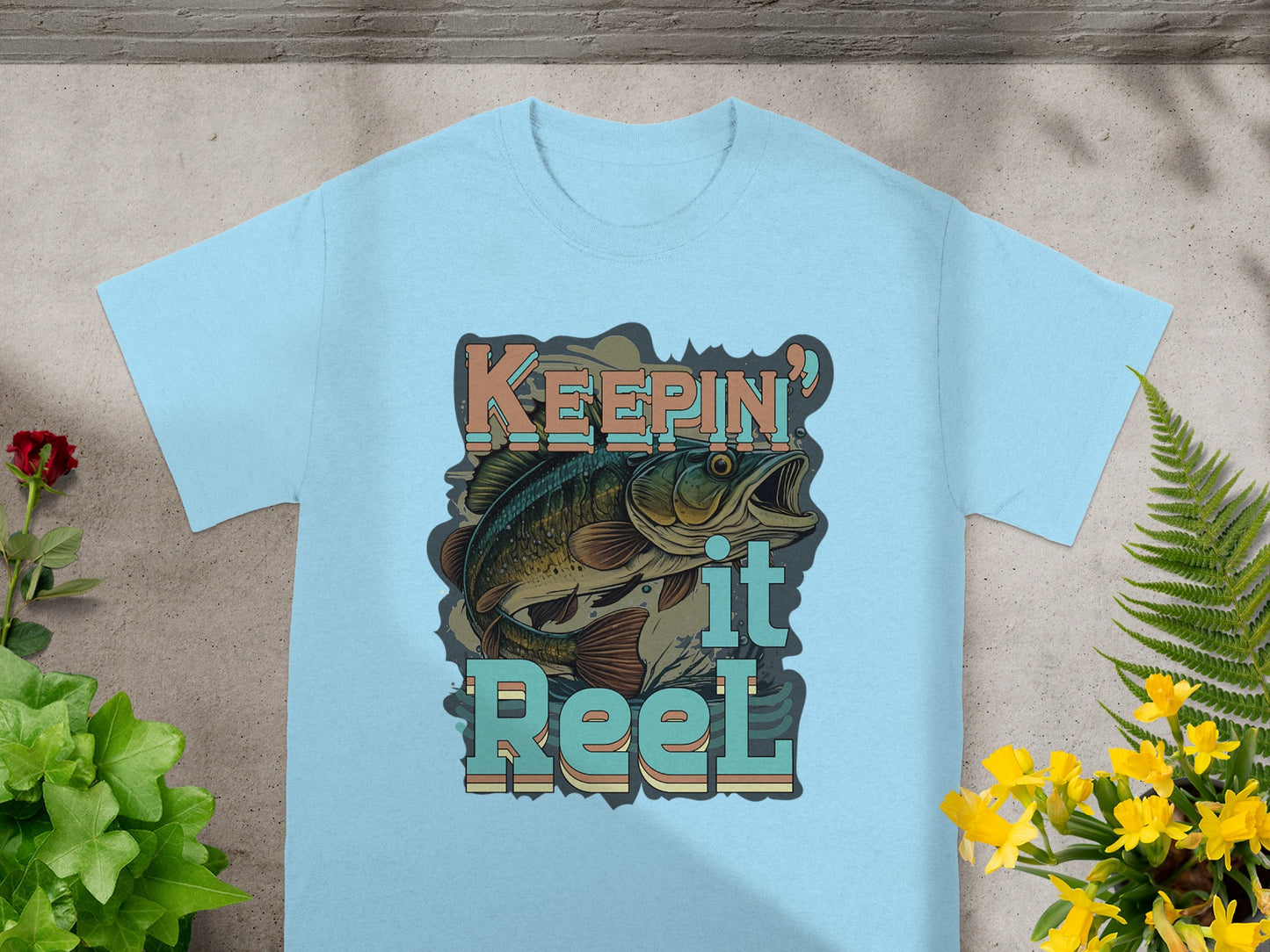 Light blue t-shirt featuring a bass fish graphic and text "Keepin' it Reel".