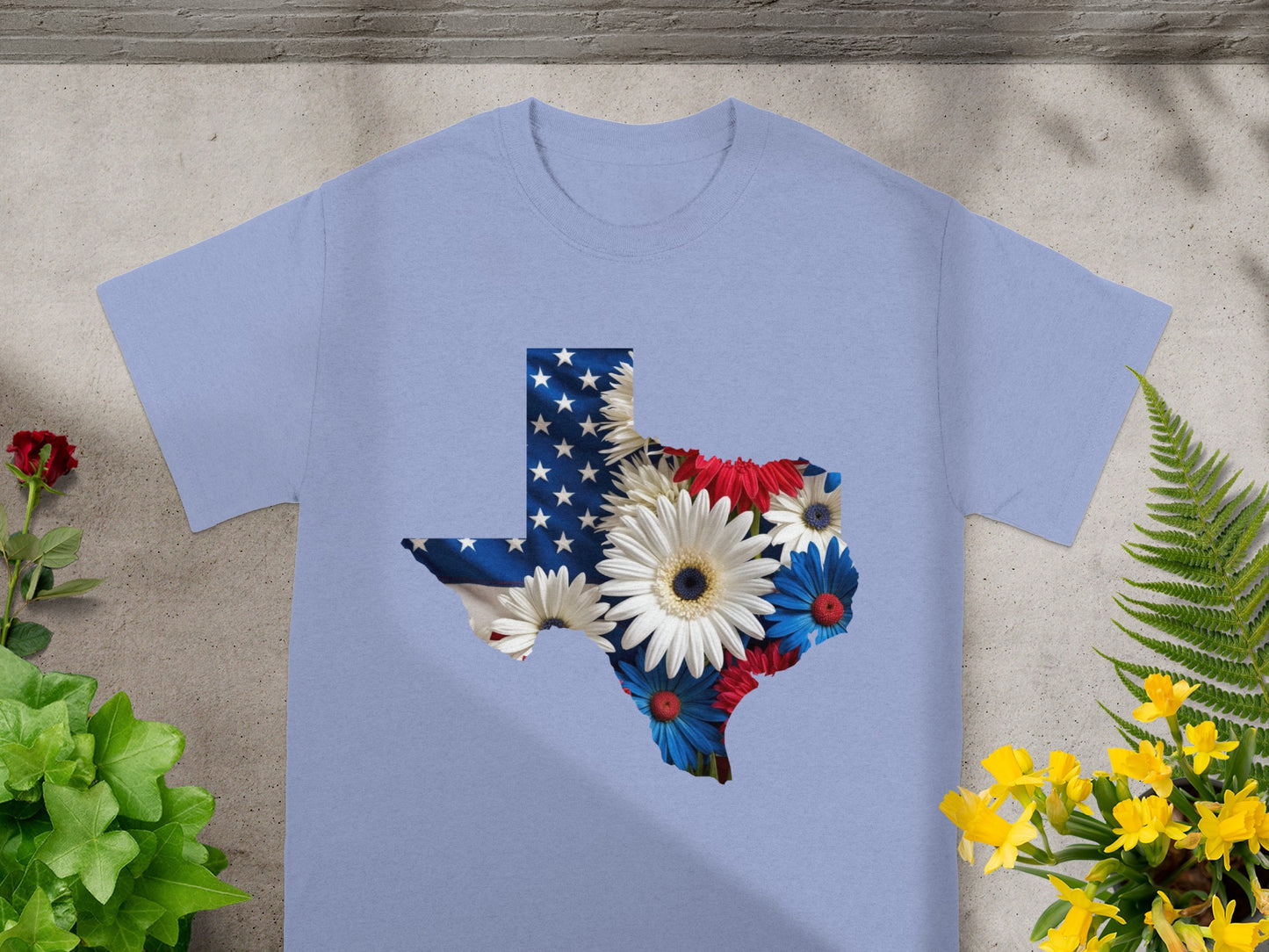 Light blue t-shirt with Texas shape filled with American flag and patriotic flowers.