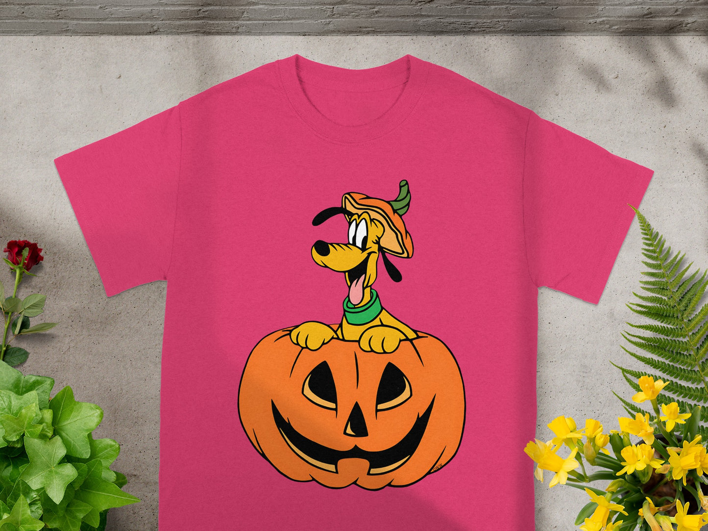 Pink t-shirt featuring Pluto wearing a pumpkin hat peeking out of a jack-o'-lantern.