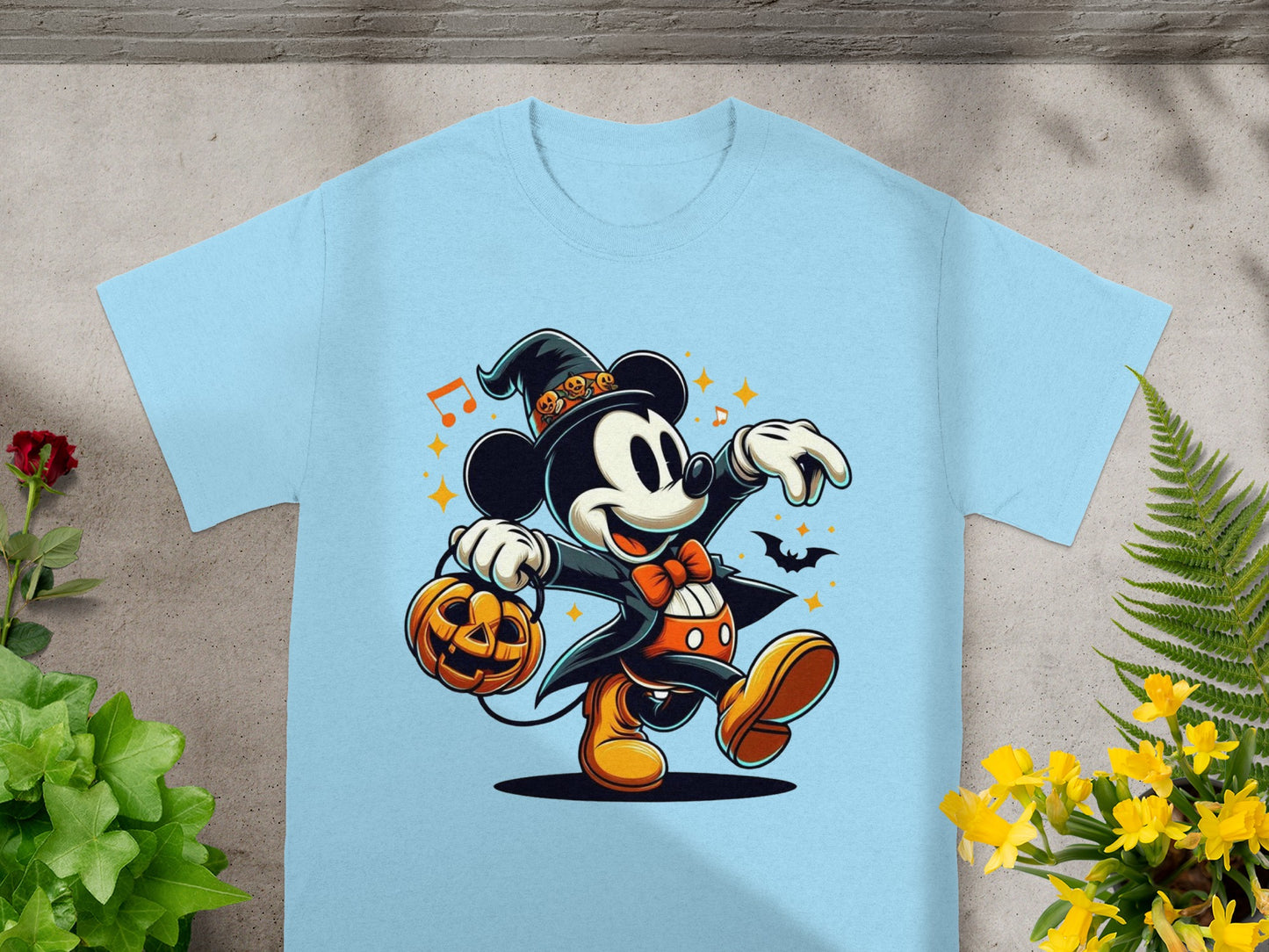 Mickey Mouse wearing a witch hat and tuxedo, carrying a pumpkin on a light blue t-shirt.