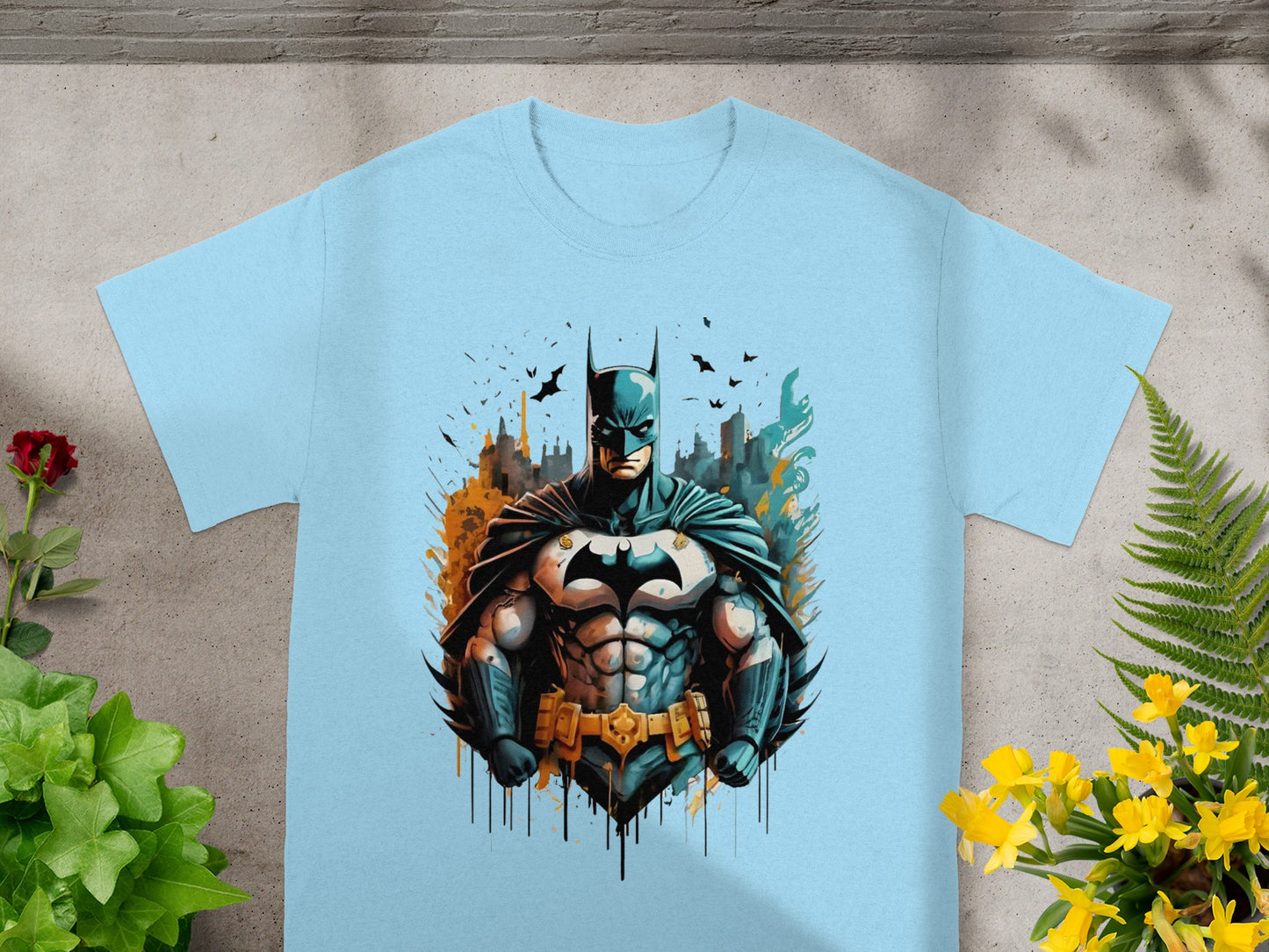 Light blue t-shirt with Batman illustration, cityscape background, yellow and orange accents.