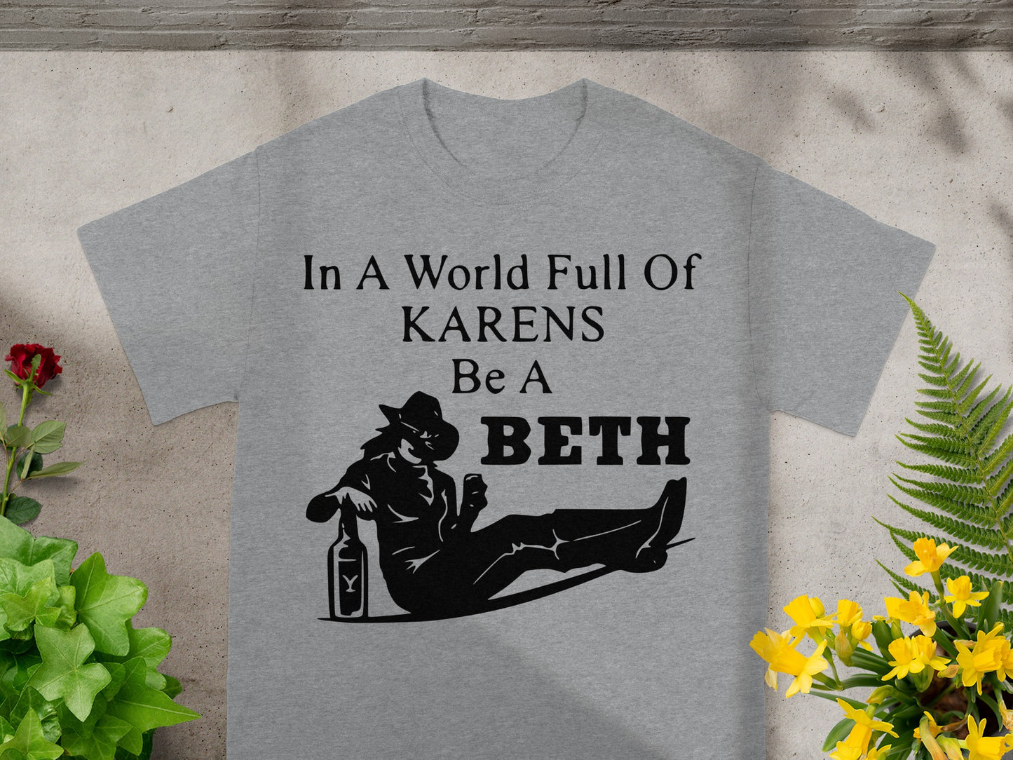 Grey t-shirt with text "In A World Full Of KARENS Be A BETH" and silhouette.