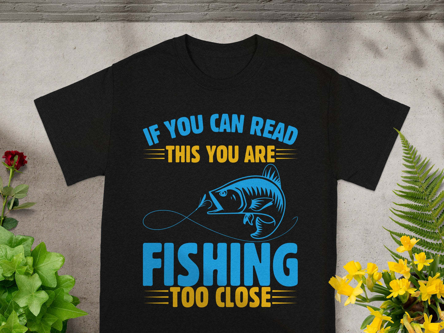 Black t-shirt with blue and yellow text saying "IF YOU CAN READ THIS YOU ARE FISHING TOO CLOSE".
