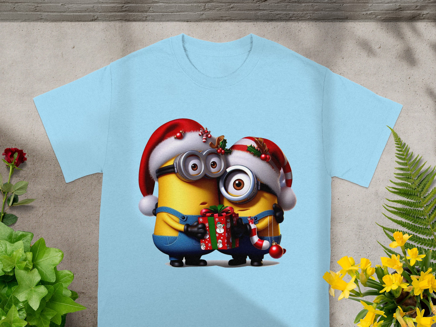 Two Minions in Santa hats hug a gift and Christmas ornament.