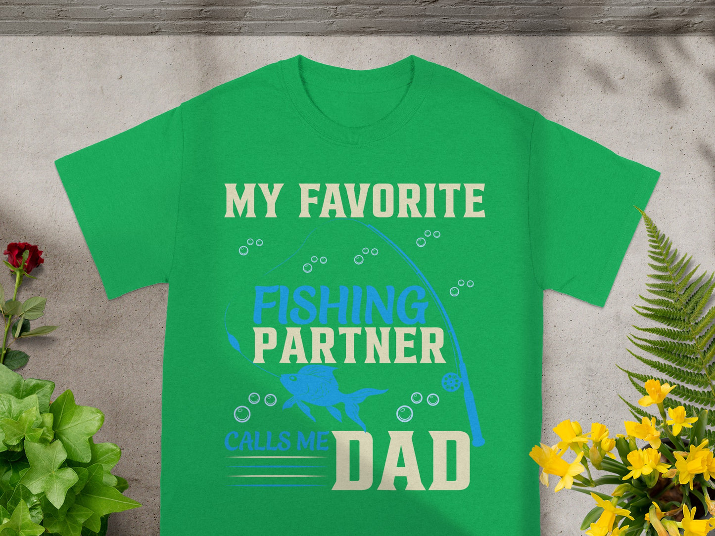 Green t-shirt with "My Favorite Fishing Partner Calls Me Dad" text and fishing graphics.