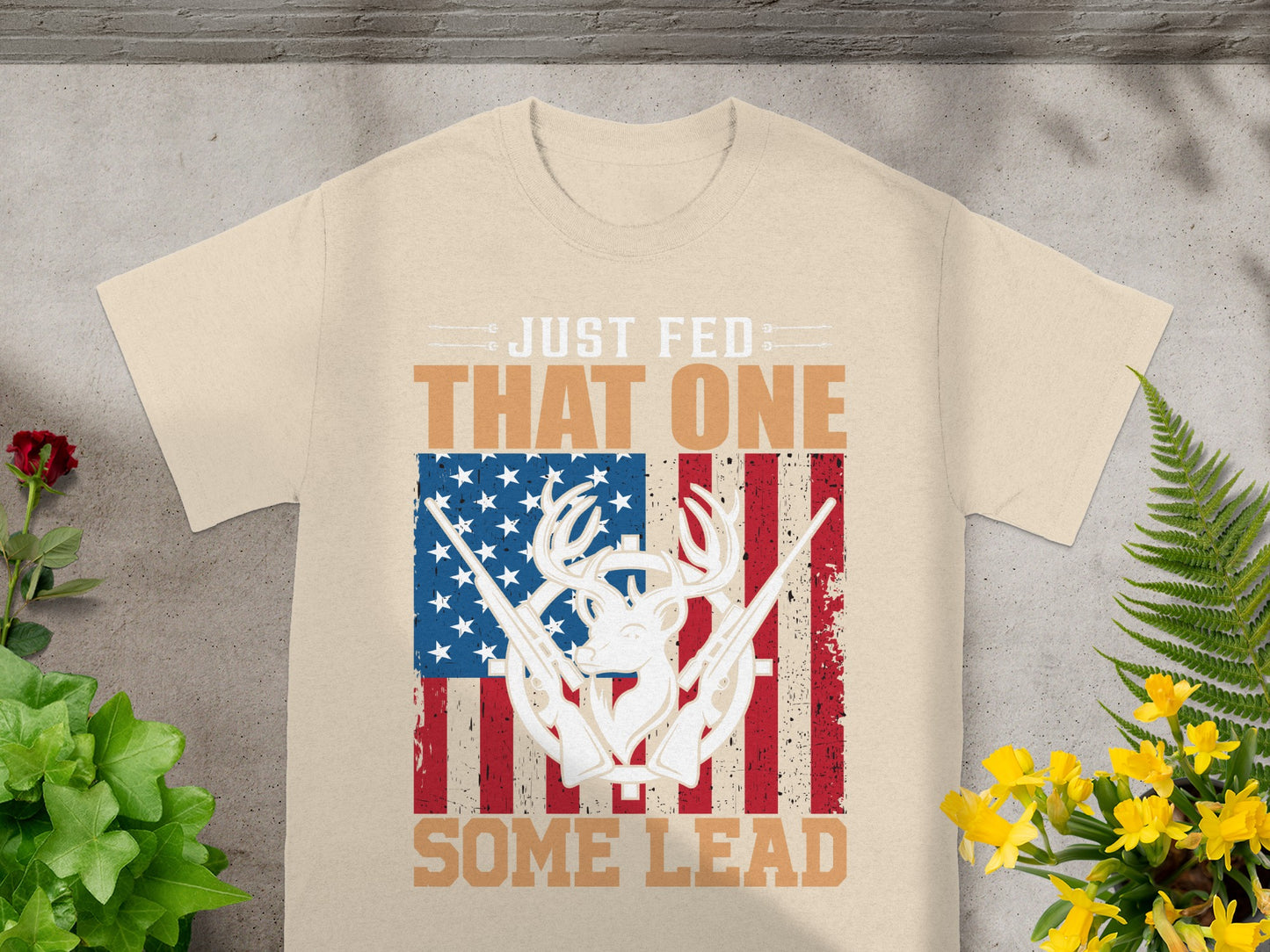 Graphic t-shirt with American flag, stag silhouette, and guns. Text reads "JUST FED THAT ONE SOME LEAD".